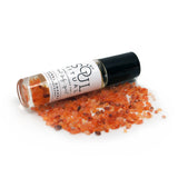 Sacral Chakra roller bottle laying on crushed carnelian crystals. Soul Ritual chakra roller bottle collection for sacral chakra infused with reiki, carnelian and chakra essential oil blend for your energetic well-being.